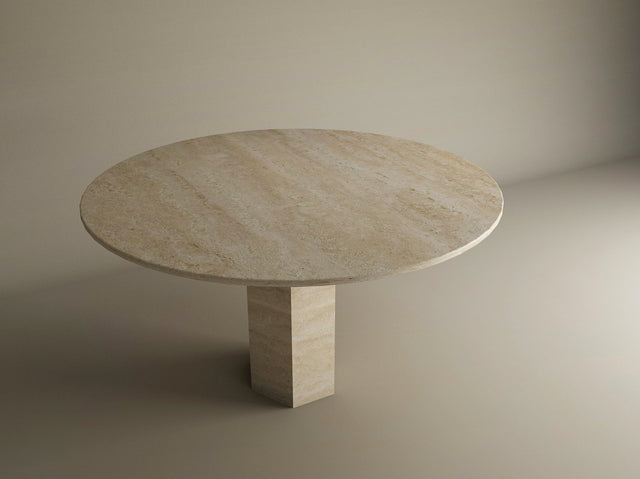 The TRAVERTABLE Oval Travertine Dining Table features geometric elegance with a hexagonal center base, crafted in beige travertine and set against a neutral backdrop. Customizable for your dining space.