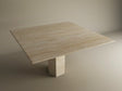 The TRAVERTABLE Square Travertine Dining Table features a light beige natural stone top and a bold hexagonal center base, blending geometric style with customization options, shown against a neutral backdrop.