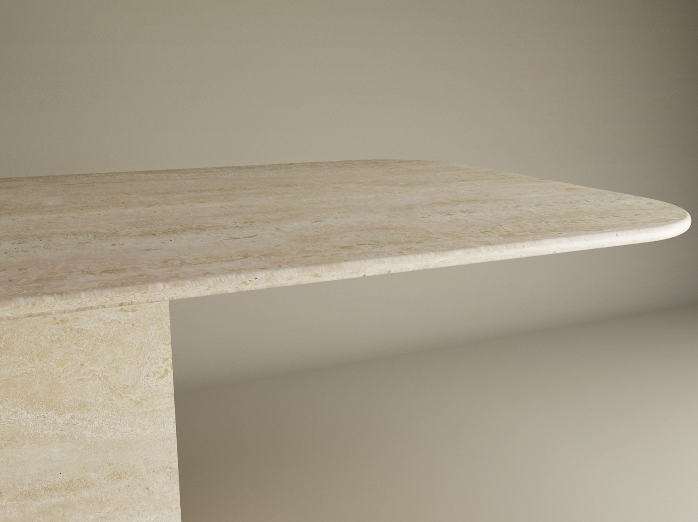 A close-up of the TRAVERTABLE Rectangular Travertine Dining Table with Block Base shows its thick natural stone top, rounded edges, and sturdy base, set against a plain background. Customizable design by TRAVERTABLE.