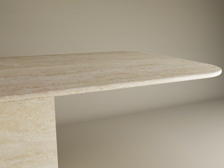 A close-up of the TRAVERTABLE Rectangular Travertine Dining Table with Block Base shows its thick natural stone top, rounded edges, and sturdy base, set against a plain background. Customizable design by TRAVERTABLE.