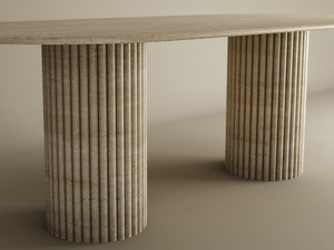 The TRAVERTABLE Oval Travertine Dining Table features a natural stone tabletop and two fluted, vertical groove bases. Its plain, neutral background highlights this customizable heirloom piece’s timeless design.