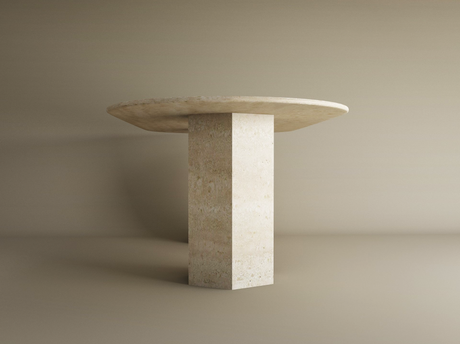The TRAVERTABLE Oval Travertine Dining Table features a natural stone top and a hexagonal pedestal base, set against a neutral background. This customizable dining table combines organic style with elegant design.